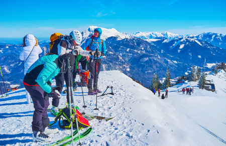 ST GILGEN, AUSTRIA - FEBRUARY 23, 2019: The group of skiers prepares to downhill from the Zwolferhorn mountain peak, on February 23 in St Gilgenのeditorial素材