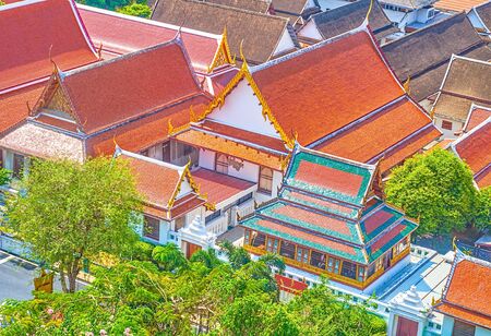 The monastic houses of Wat Saket (Golden Mount) temple complex finished in typic Thai religion style with carved decoration and tiled roofs, Bangkok, Thailandの写真素材
