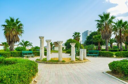 Walk the scenic park with topiary bushes, tall palm trees, benches and ruins of antique columns with...