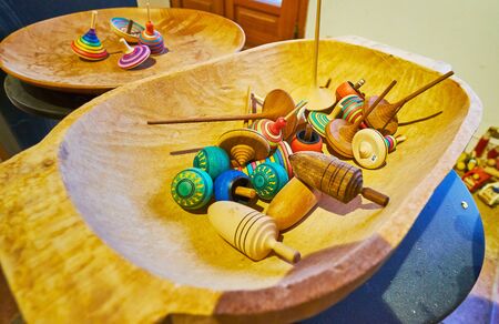 The carved bowl with handmade wooden whirlabouts of different color and shape in carpenter workshop of Halltatt, Salzkammergut, Austriaの写真素材