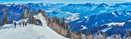 ST GILGEN, AUSTRIA - FEBRUARY 23, 2019: Panorama of hazy snowy Alps and Wolfgangsee lake from the...