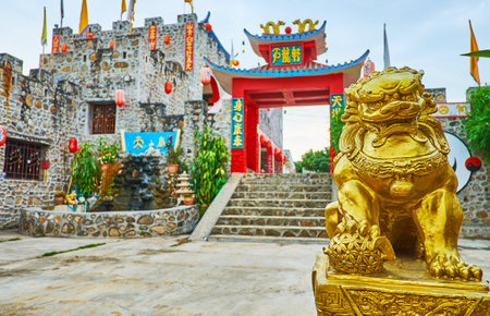 SANTICHON, THAILAND - MAY 5, 2019: Small golden foo dog (Imperial lion) guards the gate of the castle of Chinese Yunnan cultural village, on May 5 in Santichonのeditorial素材