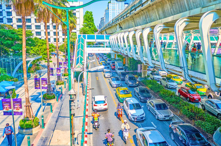 BANGKOK, THAILAND - APRIL 24, 2019: The modern pedestrian skywalk along busy Ratchaprasong road with the line of (BTS) Skytrain above, on April 24 in Bangkokのeditorial素材