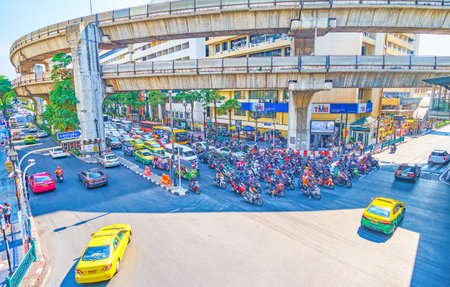 BANGKOK, THAILAND - APRIL 24, 2019: The busy traffic in Ratchaprasong junction, cars stand at traffic light under the railway bridge of BTS (Skytrain) line, on April 24 in Bangkokのeditorial素材