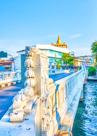 The Phanfa bridge with decorative stone sculptures on the railings and the Golden mount temple of the background, Bangkok, Thailandのeditorial素材