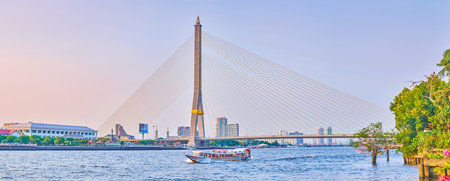 BANGKOK, THAILAND - APRIL 24, 2019: The scenic view on rivers of Chao Phraya river with stone Rama XIII Bridge and fasm moving tourist ship, on April 24 in Bangkokのeditorial素材