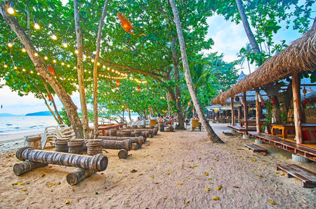 AO NANG, THAILAND - APRIL 25, 2019: The lush tropical greenery hides the wooden huts of beach cafes and bars with cozy open air terraces and lounge zones, on April 25 in Ao Nangのeditorial素材