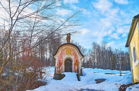 BAD ISCHL, AUSTRIA - FEBRUARY 25, 2019: The small Calvary Chapel on the snowy mountain slope, located next to Kalvarienbergkirche church, on February 25 in Bad Ischlの写真素材