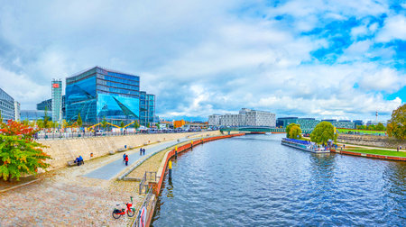 BERLIN, GERMANY - OCTOBER 3, 2019: The wide pedestrian embankment of Spree river in center of the city with surrounding modern office and government buildings, on October 3 in Berlinのeditorial素材