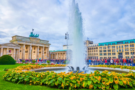 BERLIN, GERMANY - OCTOBER 3, 2019: The left fountain with the small garden on Pariser Platz with a view on Brandenburg Gate on background, on October 3 in Berlinのeditorial素材