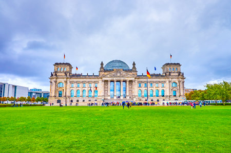 Reichstag with its restored glass dome is one of the most notable landmarks in Berlin, tourists love to walk on large Platz der Republik and make selfies with this masterpiece of Germany architecture.のeditorial素材