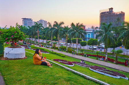 YANGON, MYANMAR - MARCH 2, 2018: Inya lake park boasts juicy green lawn, topiary plants, blooming bushes and colorful flower beds, on March 2 in Yangonのeditorial素材