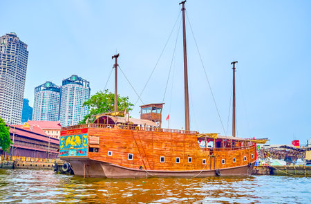 BANGKOK, THAILAND - APRIL 15, 2019: The large wooden ship serves as the restaurant and moored at the pier in old docks, nowadays the amusement park, on April 15 in Bangkokのeditorial素材