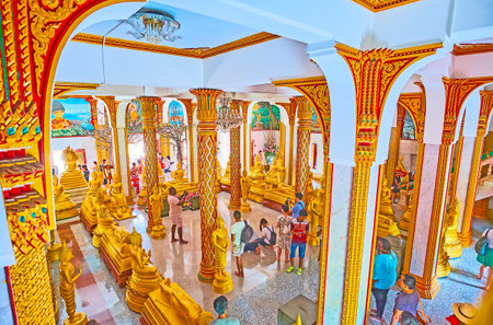 CHALONG, THAILAND - APRIL 30, 2019: The large column hall of Wat Chalong Pagoda with gilt carved ornaments, Buddha Images and frescoes of Buddha life, on April 30 in Chalongのeditorial素材
