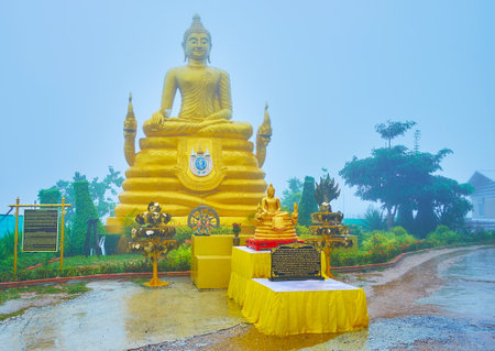 CHALONG, THAILAND - APRIL 30, 2019: The rain on territory of Ming Mongkol Buddha Temple (Big Buddha Temple); the blue fog gathers around the golden statue of Buddha, sitting on Naga serpents, on April 30 in Chalongのeditorial素材
