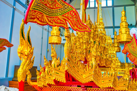 BANGKOK, THAILAND - APRIL 15, 2019: The scenic gilden carved decorations of the Royal Charity with numerous Nagas with shiny eyes in National Museum, on April 15 in Bangkokのeditorial素材