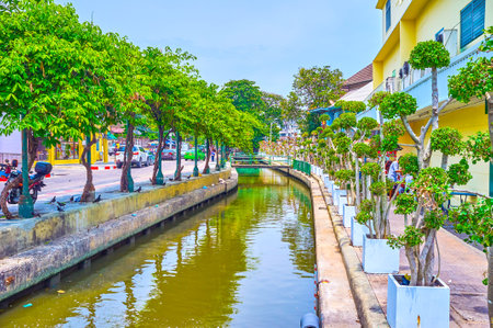 BANGKOK, THAILAND - APRIL 15, 2019: The residential street with trees in pots along the  narrow canal and small bridges across it, on April 15 in Bangkokのeditorial素材