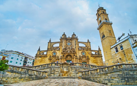 JEREZ, SPAIN - SEPTEMBER 20, 2019: The medieval architectural ensemble of Holy Saviour Cathedral with complex staircase, scenic facade with flying buttresses, carvings, sculptures and tall bell tower, on September 20 in Jerezのeditorial素材