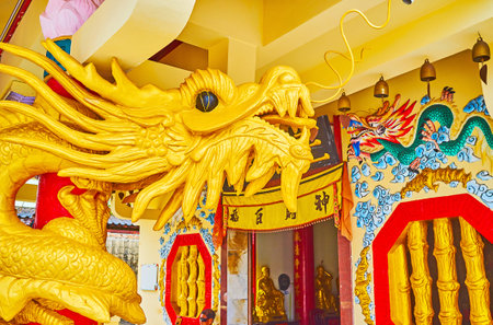 PHUKET, THAILAND - APRIL 30, 2019: The head of golden dragon in front of Sam Sae Chu Hut Chinese Shrine with carved details, on April 30 in Phuketのeditorial素材