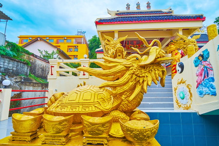 PHUKET, THAILAND - APRIL 30, 2019: Close-up of golden turtle-dragon - mythical creation, symbol of luck and prosperity, located in front of Sam Sae Chu Hut Chinese Shrine, on April 30 in Phuketのeditorial素材