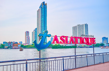BANGKOK, THAILAND - APRIL 15, 2019: The signboard of Asiatique shopping mall on its promenade with modern buildings on the background, on April 15 in Bangkokのeditorial素材
