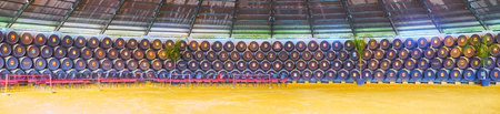 JEREZ, SPAIN - SEPTEMBER 20, 2019: Panorama of Real Bodega de la Concha of Tio Pepe winery with hundreds of oak casks with brand name and flags of countries, where Gonzalez Byass wines are exported, on September 20 in Jerezのeditorial素材