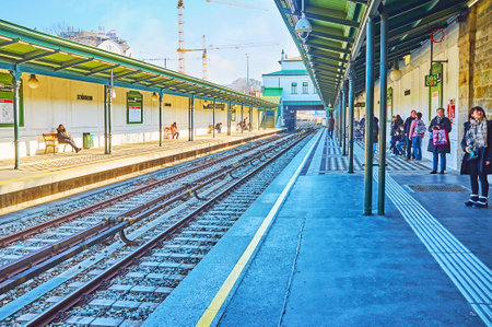 VIENNA, AUSTRIA - FEBRUARY 19, 2019: The Schonbrunn U-Bahn (metro) station with arriving train and passengers, waiting at the platform, on February 19 in Viennaのeditorial素材