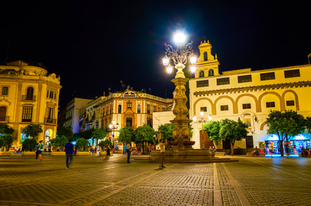 SEVILLE, SPAIN - OCTOBER 1, 2019: Tourists walk in Plaza Virgen de los Reyes the most beloved place in old town in surrounding of historical landmarks, on October 1 in Sevilleのeditorial素材