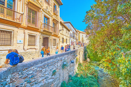 GRANADA, SPAIN - SEPTEMBER 25, 2019: Walk the medieval stone embankment of  Darro river, named Carrera del Darro street, located in Albaicin district of Old Town, on September 25 in Granadaのeditorial素材