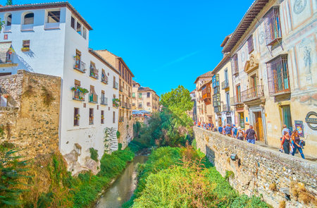 GRANADA, SPAIN - SEPTEMBER 25, 2019: Crowded Carrera del Darro street of Albaicin district, located in gorge and lined by Darro river, historical edifices and mansions, on September 25 in Granadaのeditorial素材