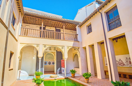 GRANADA, SPAIN - SEPTEMBER 25, 2019: The beautiful court of medieval Arabic Casa de Zafra with a pond, arcade, carved arabesques and wooden terrace, on September 25 in Granadaのeditorial素材