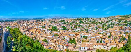 Alcazaba fortress is perfect viewpoint to enjoy the vista of old Granada, its small houses with tile roofs, medieval churches, green cypress trees and Sierra Nevada mountains on background, Spainの写真素材
