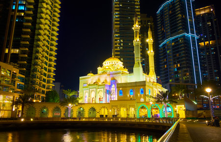 DUBAI, UAE - MARCH 2, 2020: Splendid Mohammed Bin Ahmed Al Mulla Mosque, decorated with bright evening illumination and located among the skyscrapers of Marina, on March 2 in Dubaiのeditorial素材