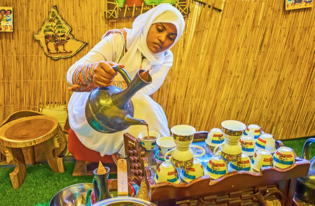 DUBAI, UAE - MARCH 2, 2020: The young woman performs Ethiopian coffee ceremony in Coffee museum and pours hot coffee, made in clay jebena pot, on March 2 in Dubaiのeditorial素材