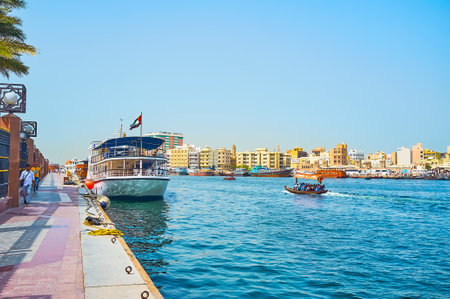 DUBAI, UAE - MARCH 2, 2020: Walk along the bank of Al Fahidi district and watch abra and dhow boats, floating along Dubai Creek, on March 2 in Dubaiのeditorial素材