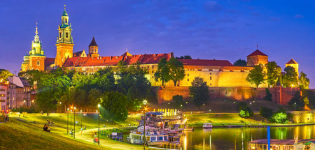 The amazing medieval Wawel Castle in evening lights and the youth relaxing on grass and walk along promenade, Krakow, Polandのeditorial素材