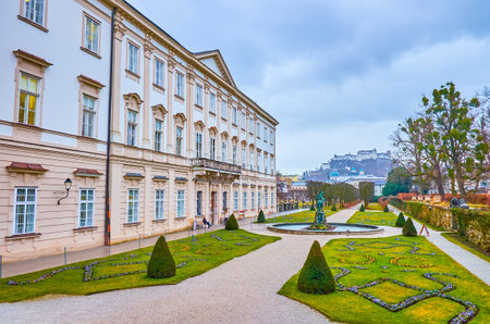 SALZBURG, AUSTRIA - MARCH 1, 2019: The scenic view on Mirabell Palace with its gardens and Hohensalzburg castle on the background, on March 1 in Salzburg