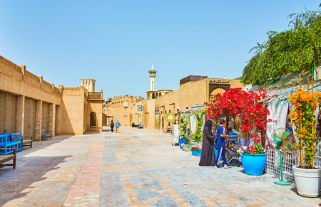 DUBAI, UAE - MARCH 2, 2020: The small square in Al Bastakiya (Al Fahidi) neighborhood with clay houses and cozy cafe, decorated with blooming bougainvillea bushes, on March 2 in Dubaiのeditorial素材