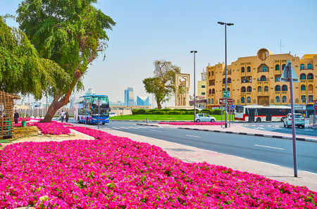 DUBAI, UAE - MARCH 2, 2020: The Al Fahidi roundabout is lined with living quarters and bright pink petunia flower beds, on March 2 in Dubaiのeditorial素材