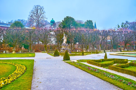 SALZBURG, AUSTRIA - MARCH 1, 2019: The  ornamental Mirabell Garden boasts carved stone sculptures, trimmen plants, and winter flower beds, on March 1 in Salzburgのeditorial素材