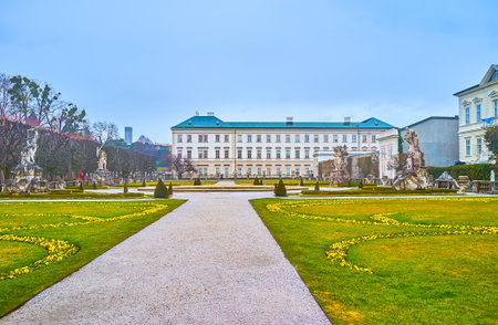 SALZBURG, AUSTRIA - MARCH 1, 2019: The stunning ornamental garden with antique style sculptures and large Mirabell Palace on the background, on March 1 in Salzburgのeditorial素材