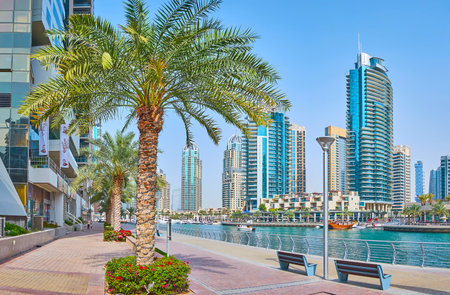 DUBAI, UAE - MARCH 2, 2020: The comfortable promenade of Dubai Marina is perfect place to relax, explore modern high rises, walk in shade of lush palm trees and watch the floating boats, on March 2 in Dubaiのeditorial素材