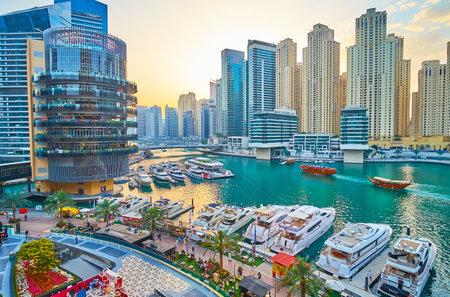 DUBAI, UAE - MARCH 2, 2020: Dhow boat cruise throug the canal of Dubai Marina with a view on yachts at Marina Mall and forest of futuristic residential skyscrapers, on March 2 in Dubaiのeditorial素材