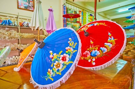 The colorful umbrellas, decorated with floral patterns and fringe in souvenir shop of the craft villageの写真素材