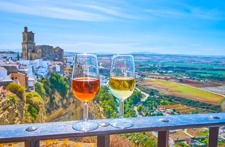 Enjoy the glass of Sherry wine with a view on medieval white town (pueblo blanco) of Arcos, located on the cliff top and famous for its unique medieval architecture, Spainの写真素材