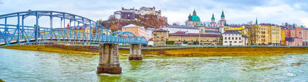 SALZBURG, AUSTRIA - MARCH 1, 2019: Panoramic view on the bank of Salzach river with medieval buildings of the oldest Altstadt district, on March 1in Salzburg, Austriaのeditorial素材