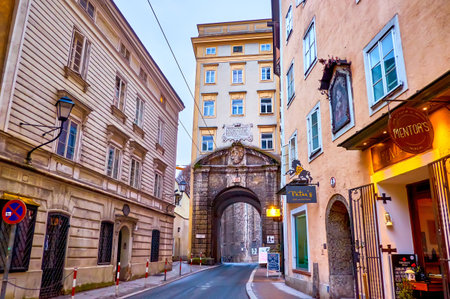 SALZBURG, AUSTRIA - MARCH 1, 2019: The medieval Gstattentor is one of the oldest city gates, located in narrow Gstattengasse street sandwiched between high buildings, on March 1 in Salzburgのeditorial素材