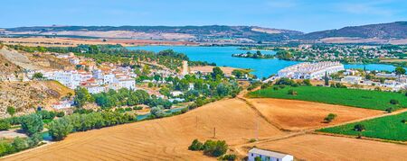 Panorama of the countryside llandscape with fields, meadows, modern white neighborhoods of Arcos and wide Guadalete river, Spainの写真素材