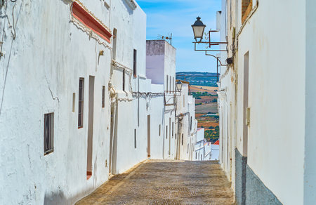 Walk the descent street with old clay living houses on both sides, Arcos, Spainのeditorial素材