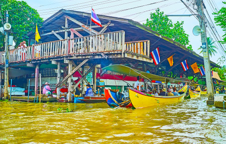 DAMNOEN SADUAK, THAILAND - MAY 13, 2019:  The fast tourist boats carry people to the different sections of Ton Khem floating market or to the bus station, on May 13 in Damnoen Saduakのeditorial素材